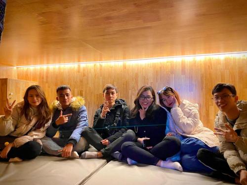 a group of people sitting on the floor posing for a picture at Sky Hotel & Homestay Ha Giang in Ha Giang