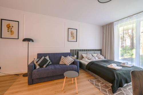a bedroom with a bed and a couch at Nadmorska FlorinaC1-Łeba in Łeba