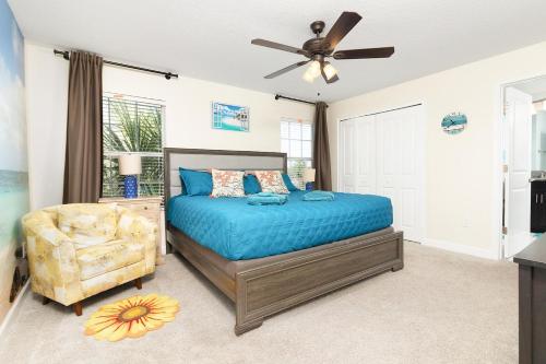 Un dormitorio con una cama y un ventilador de techo. en Bright townhouse near Disney w pool & grill, en Kissimmee
