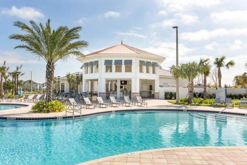 a swimming pool in front of a house at Storey Lake Pool Mins to Disney 4BR Games in Kissimmee