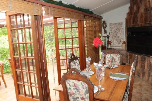 a dining room table with chairs and a wooden table at Victoria Manor in Upington