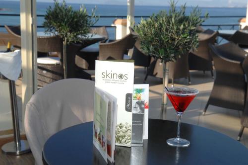 a table with a book and a glass of wine at Sea View Resorts & Spa in Karfas