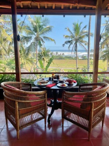 Supersenang Boutique Resort Balian في Balian: غرفة طعام مع طاولة وكرسيين