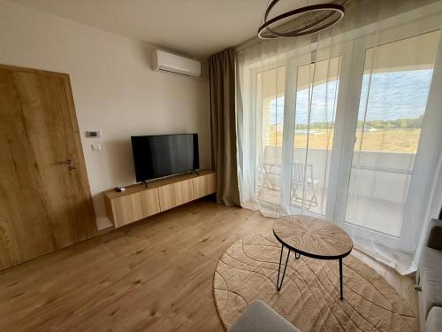 a living room with a flat screen tv and a table at Anna Apartment in Dunajská Streda