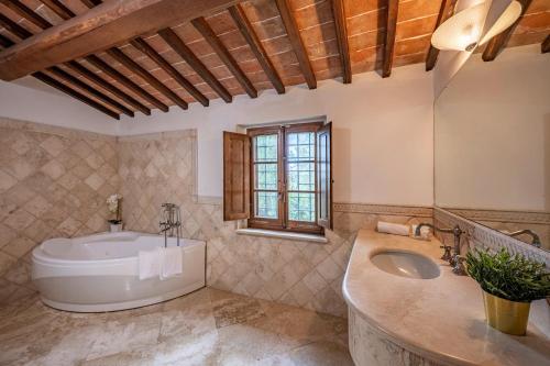 un bagno con una grande vasca e un lavandino di CASALE DEI 12, Emma Villas a Montepulciano