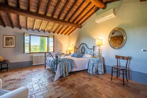 una camera da letto con un letto, un tavolo e uno specchio di CASALE DEI 12, Emma Villas a Montepulciano