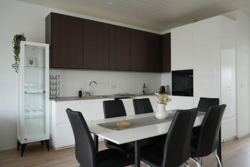 a kitchen with a table and black chairs in a kitchen at Cozy apartment in Grindavík in Grindavík