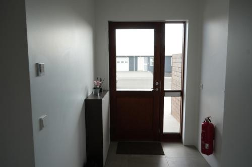 a hallway with a wooden door and a window at Cozy apartment in Grindavík in Grindavík