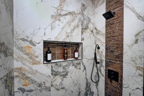 a bathroom with a shower with bottles of wine at Jungle Bungalow in Indianapolis