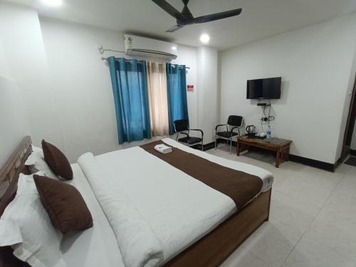 a bedroom with a large bed and a tv at Hotel New Ganga in Guwahati