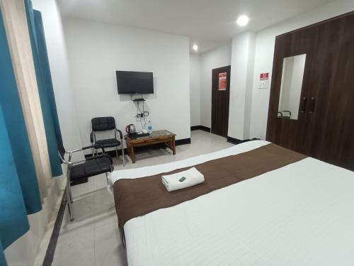 a hotel room with a bed and a television at Hotel New Ganga in Guwahati