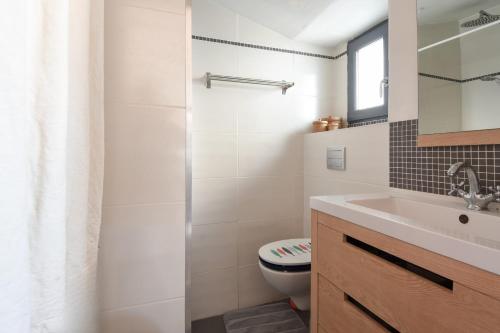 une salle de bain blanche avec des toilettes et un lavabo dans l'établissement Maison pour 4 avec jardin et terrasse - 500m plage, à Barbâtre