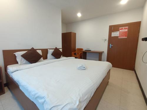 a bedroom with a large bed with white sheets at Hotel New Ganga in Guwahati