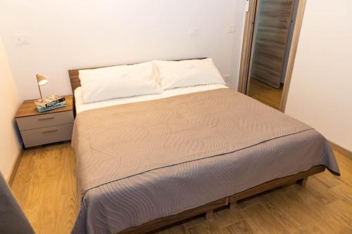 a bed in a small room with a night stand at Casa Vacanza Cry in Adro