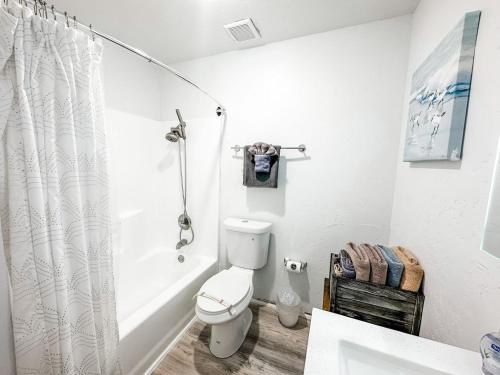 a white bathroom with a toilet and a shower at Gaslamp 2bdrm - W Parking & 5 Beds #303 in San Diego