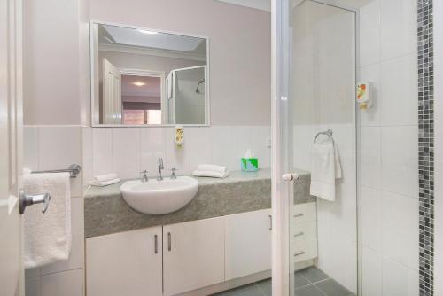 ein weißes Badezimmer mit Waschbecken und Dusche in der Unterkunft HME Collection Margaret River Townhouse 1 in Margaret River Town