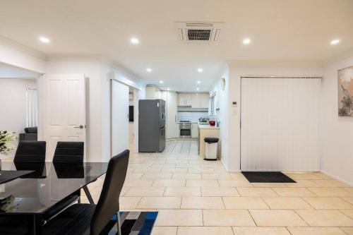 a dining room with a table and a kitchen at 5 Swan Valley Special 3br 15 Bth in Perth
