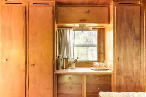 a kitchen with wooden cabinets and a window at Vintage Spartan-retro Farm Stay W Ev Charger in Arroyo Grande