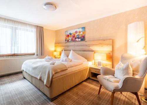 a hotel room with a bed and a chair at Chalet Ferienhaus Hubertus in Schladming