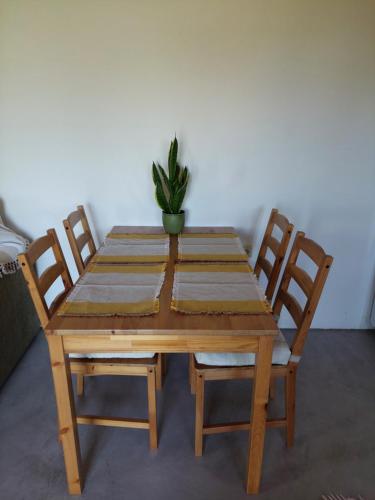 a wooden table with four chairs and a potted plant at Messinian Stone House in Messini