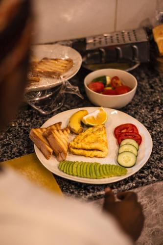 a plate of food on a counter withruit and vegetables at Mem Luxury Apartments and Hotel in Paje