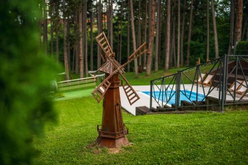 a wooden windmill in the grass next to a playground at SPA Hotel Infinity Park Velingrad in Velingrad