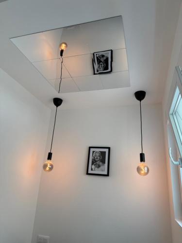 a room with three lights hanging from the ceiling at F2 Neuf Luxe Centre Haguenau Parking Gratuit in Haguenau