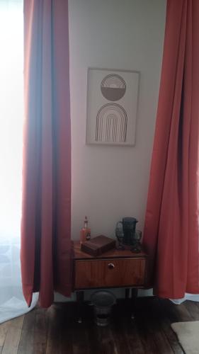 a room with red curtains and a wooden table at Le domaine du Champ Han in Saint-Hilaire-du-Harcouët