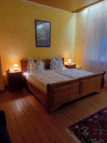 a bedroom with a wooden bed with pillows on it at Gästehaus Frevel in Münstermaifeld