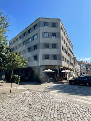 a large building on a street in front of a building at Hotel San Lázaro in Santiago de Compostela
