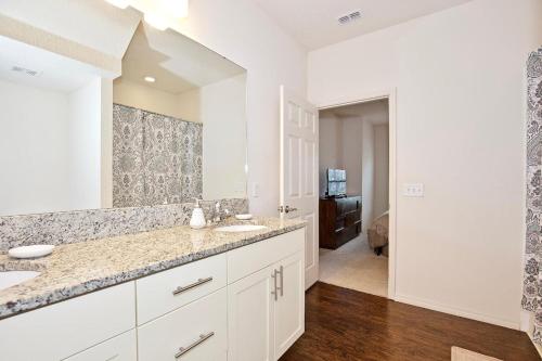 a bathroom with two sinks and a large mirror at Great and practical townhouse in gated community, sleeps 6 10 min to Disney! in Orlando