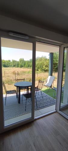 une véranda avec une table et des chaises dans l'établissement Appartement T2 meublé Dax, à Dax