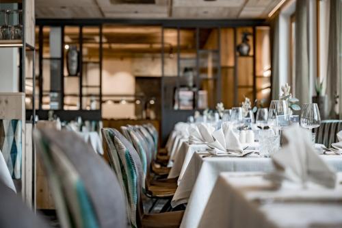 a dining room with white tables and chairs at Hotel Grauer Bär in Sölden