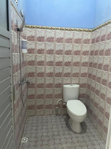 a bathroom with a toilet and a shower at Udi Inn by Secoms in Girijati