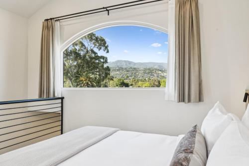 a bedroom with a bed and a large window at Casa Riviera - Boutique Apartments in Downtown Santa Barbara in Santa Barbara