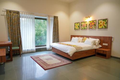 a bedroom with a bed and a large window at Rekys Home in Udaipur