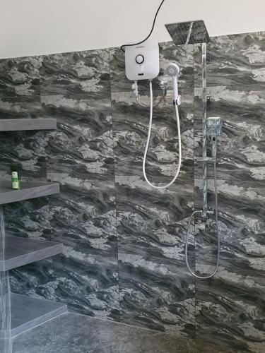 a bathroom with a shower with a stone wall at Maali holiday Apartments in Hiriketiya