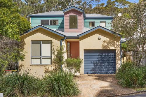 a house with a garage door in front of it at Sand Water at Hyams Beach in Hyams Beach