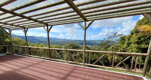 a wooden deck with a view of the mountains at Hotel Chalets Chamarel in Chamarel