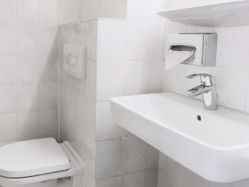 a white bathroom with a sink and a toilet at B&B HOTEL Mannheim-City in Mannheim