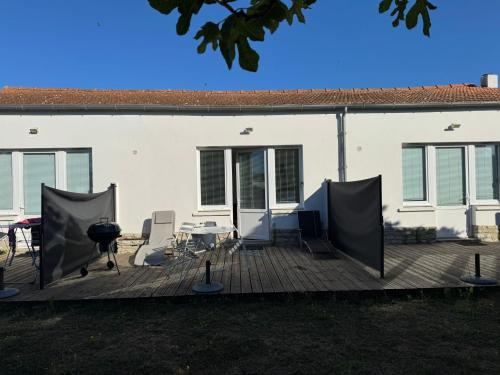 une terrasse avec un grill, une table et des chaises dans l'établissement La Tranquille - Maison pour 3 familles, à La Michelière