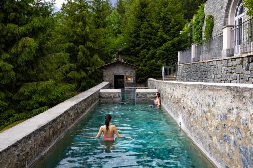 a woman in the water in a swimming pool at QC Grand Hotel Bagni Nuovi in Bormio