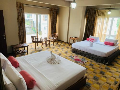 a hotel room with two beds and a living room at Seethawing by Cinnamon in Sita Eliya