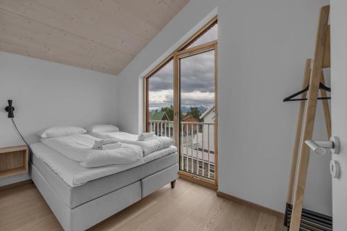 a bedroom with a bed and a large window at Northern Lights Apartments Tromsø in Tromsø