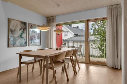 a dining room with a table and chairs and a large window at Northern Lights Apartments Tromsø in Tromsø