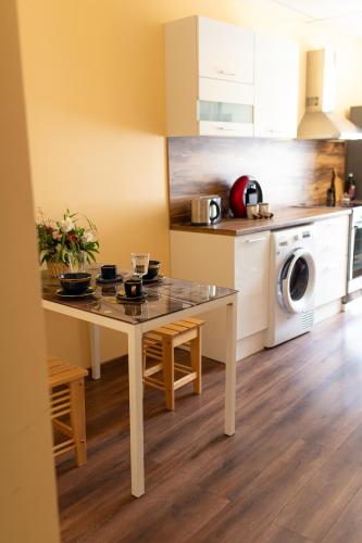a kitchen with a table in a kitchen with a washing machine at Talsu Vecpilsētas apartmenti in Talsi