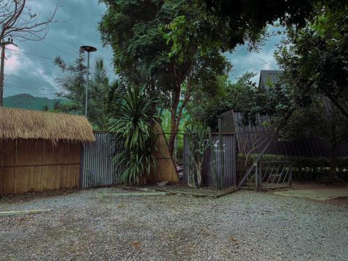 a fence with a gate and a tree and a building at นานาเพชรบูรณ์ รีสอร์ท&คาเฟ่ 