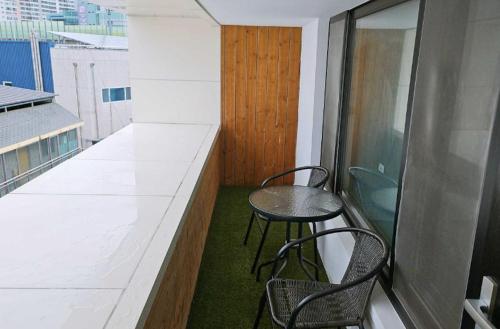a small balcony with two chairs and a table at Hotel Yaja Gwangju Mudeungsan branch in Gwangju