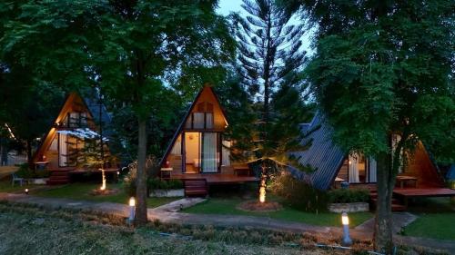 a home with two pointed roofs with lights in the yard at นานาเพชรบูรณ์ รีสอร์ท&คาเฟ่ 