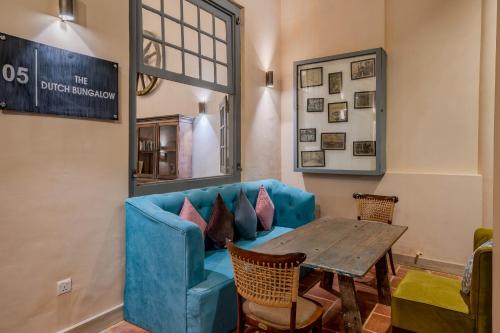 a living room with a blue couch and a table at The Dutch Bungalow in Galle